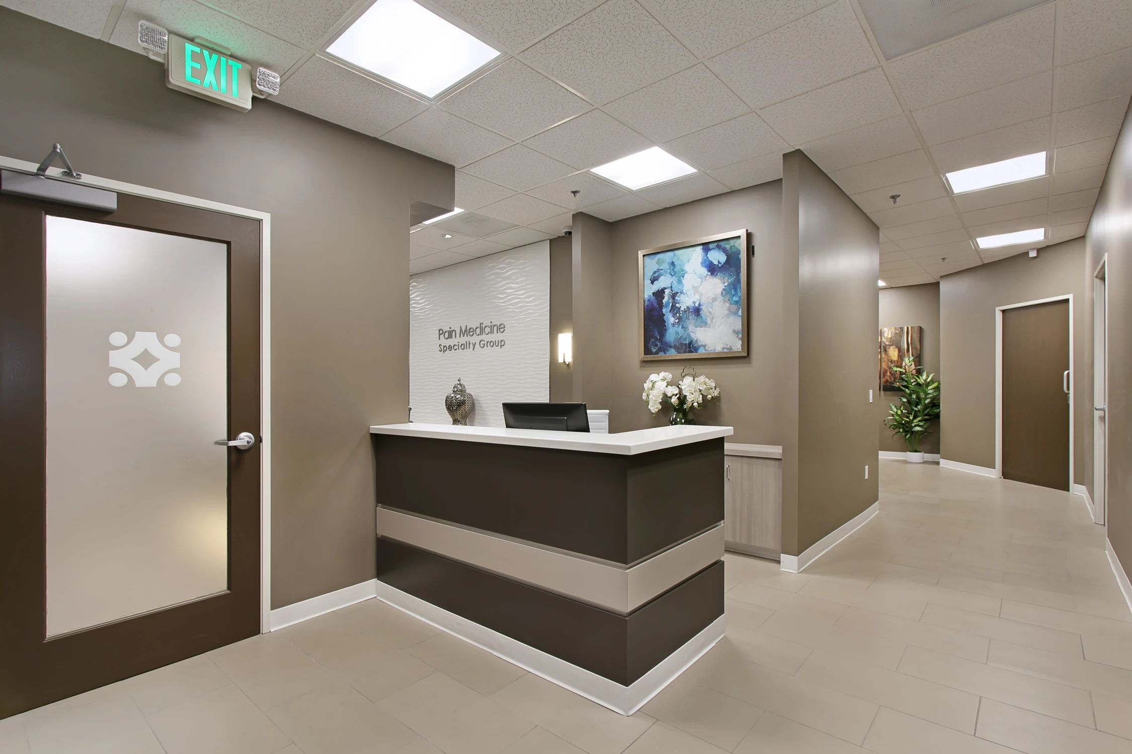 Medical office reception with dark wood desk and neutral finishes