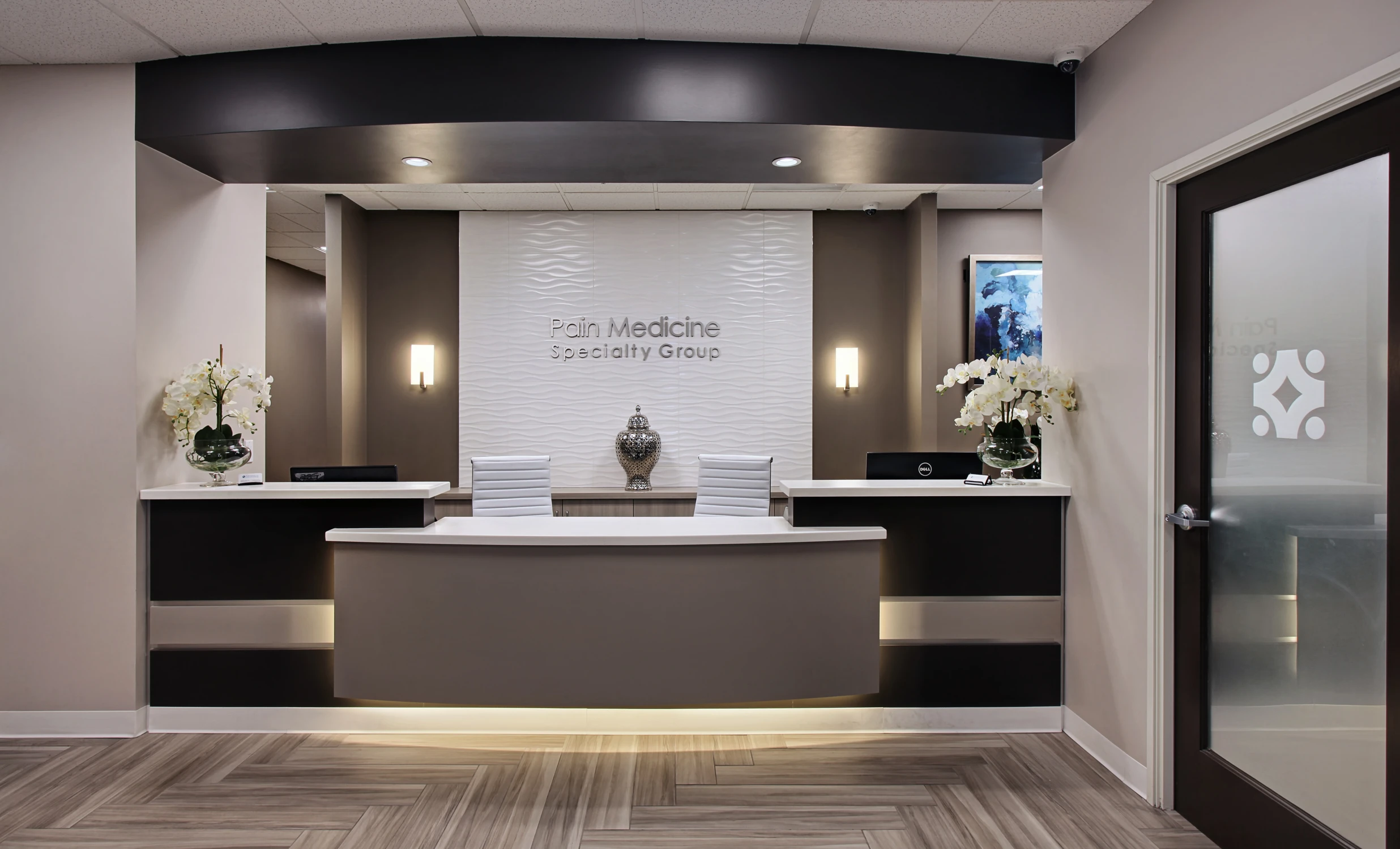 Dark reception counter beneath black ceiling soffit and wall signage