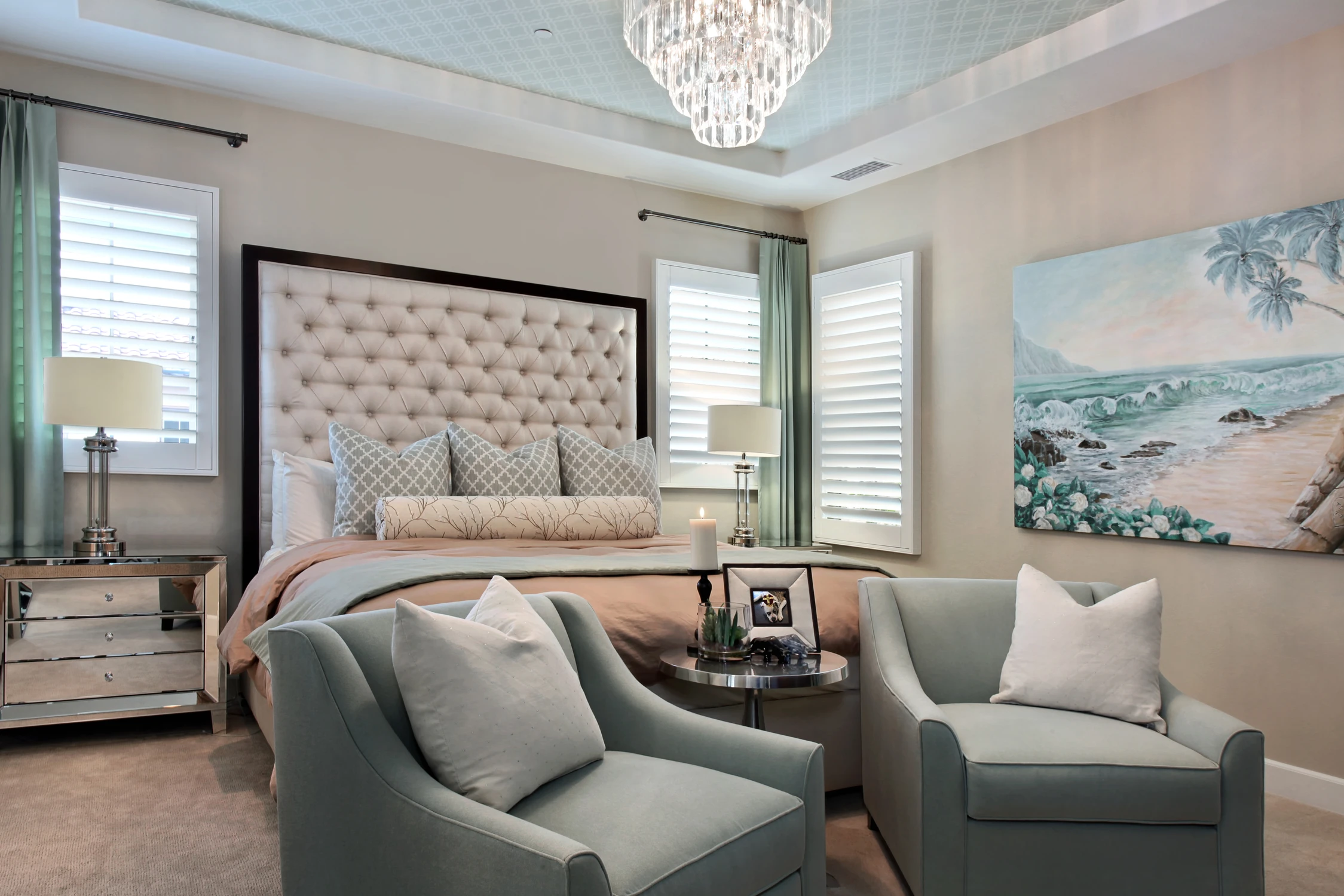 Bedroom seating arrangement with tufted bed and green armchairs
