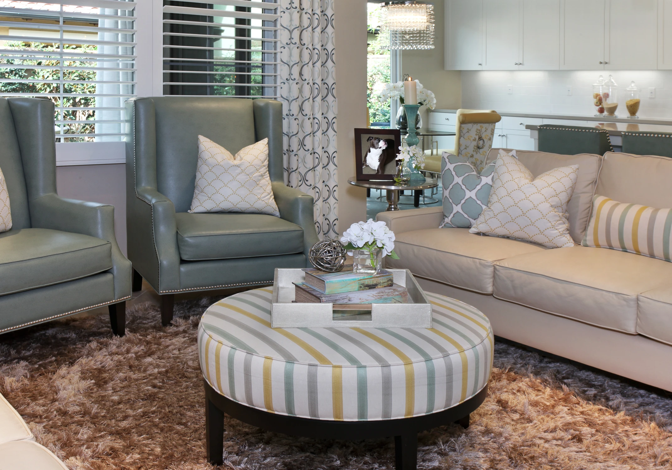 Living room seating with pale wingback chair and striped upholstered ottoman