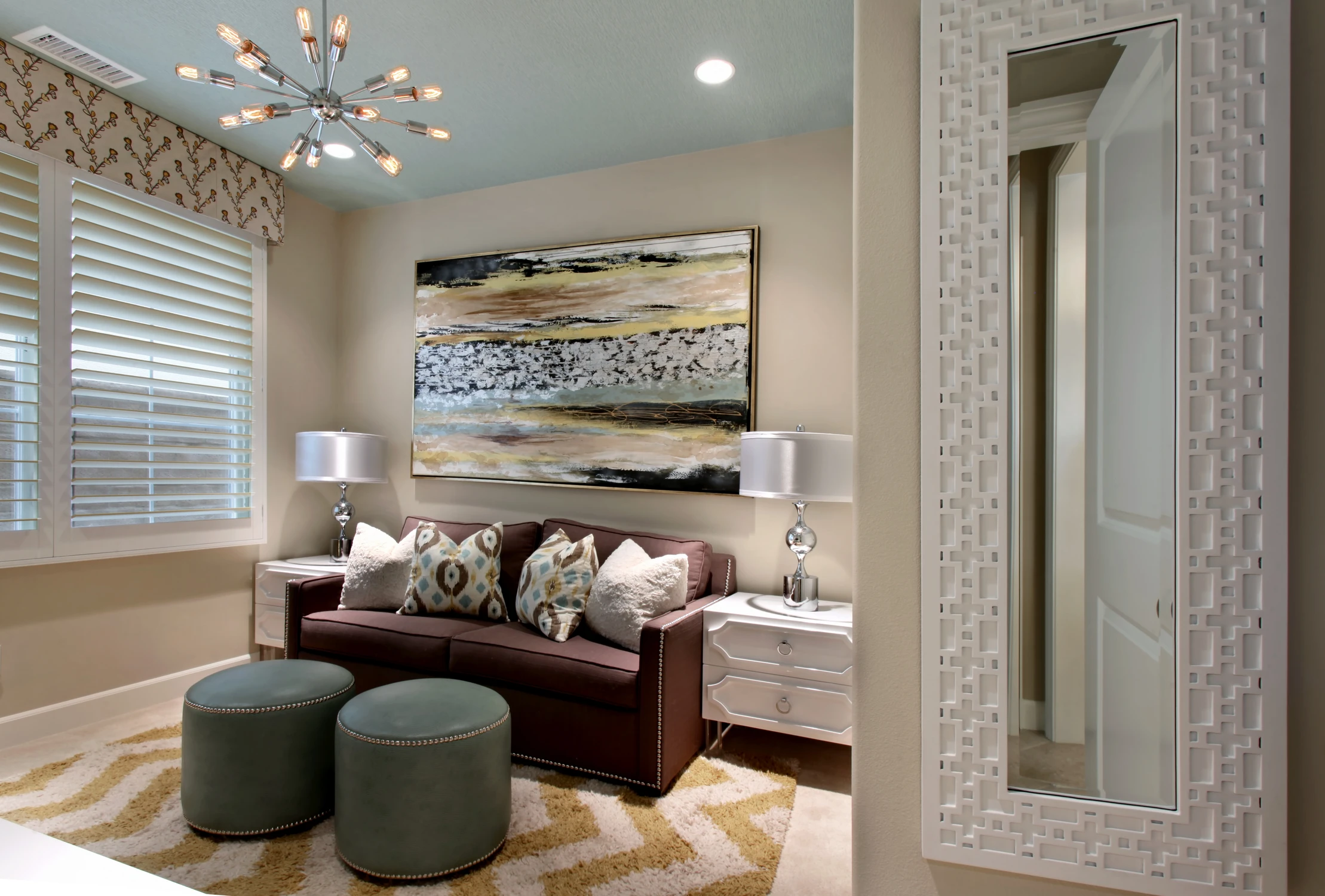 Media room with dark sofa, green ottomans, and patterned wall covering