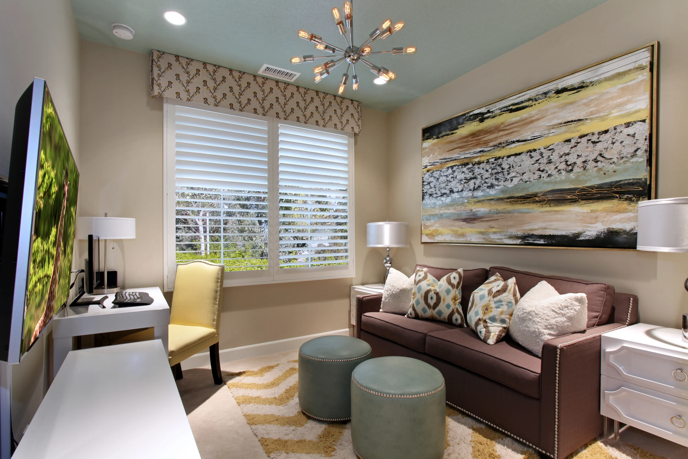 Media room with dark sofa, wall art, and starburst ceiling light