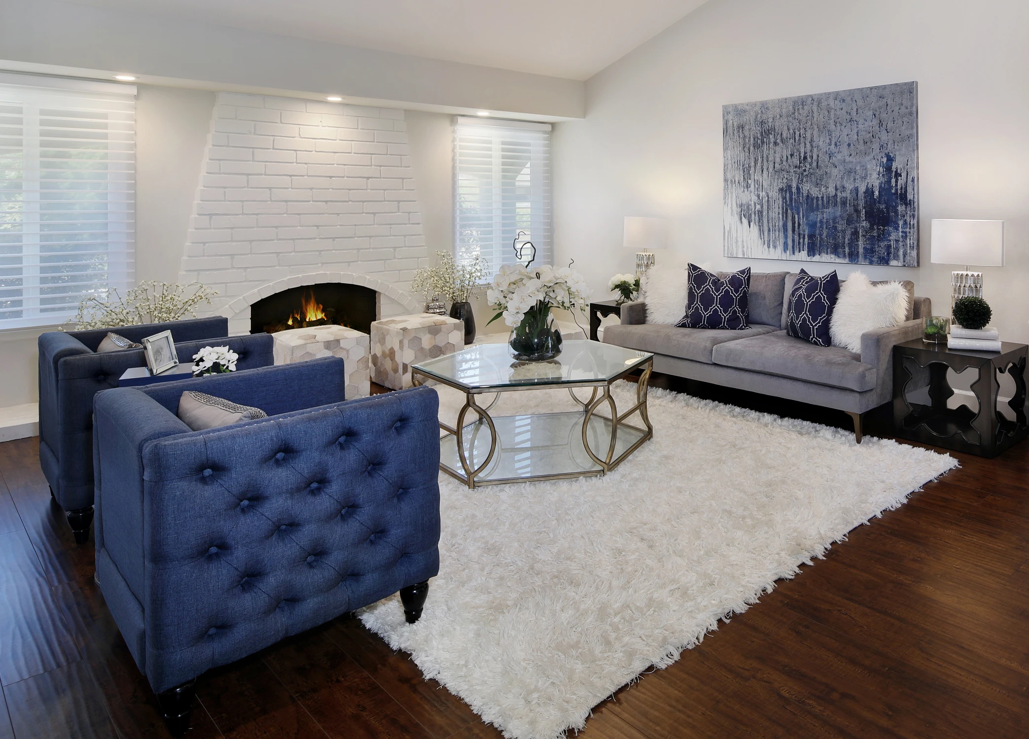 Lounge seating with navy armchair and gray sofa beside dining table