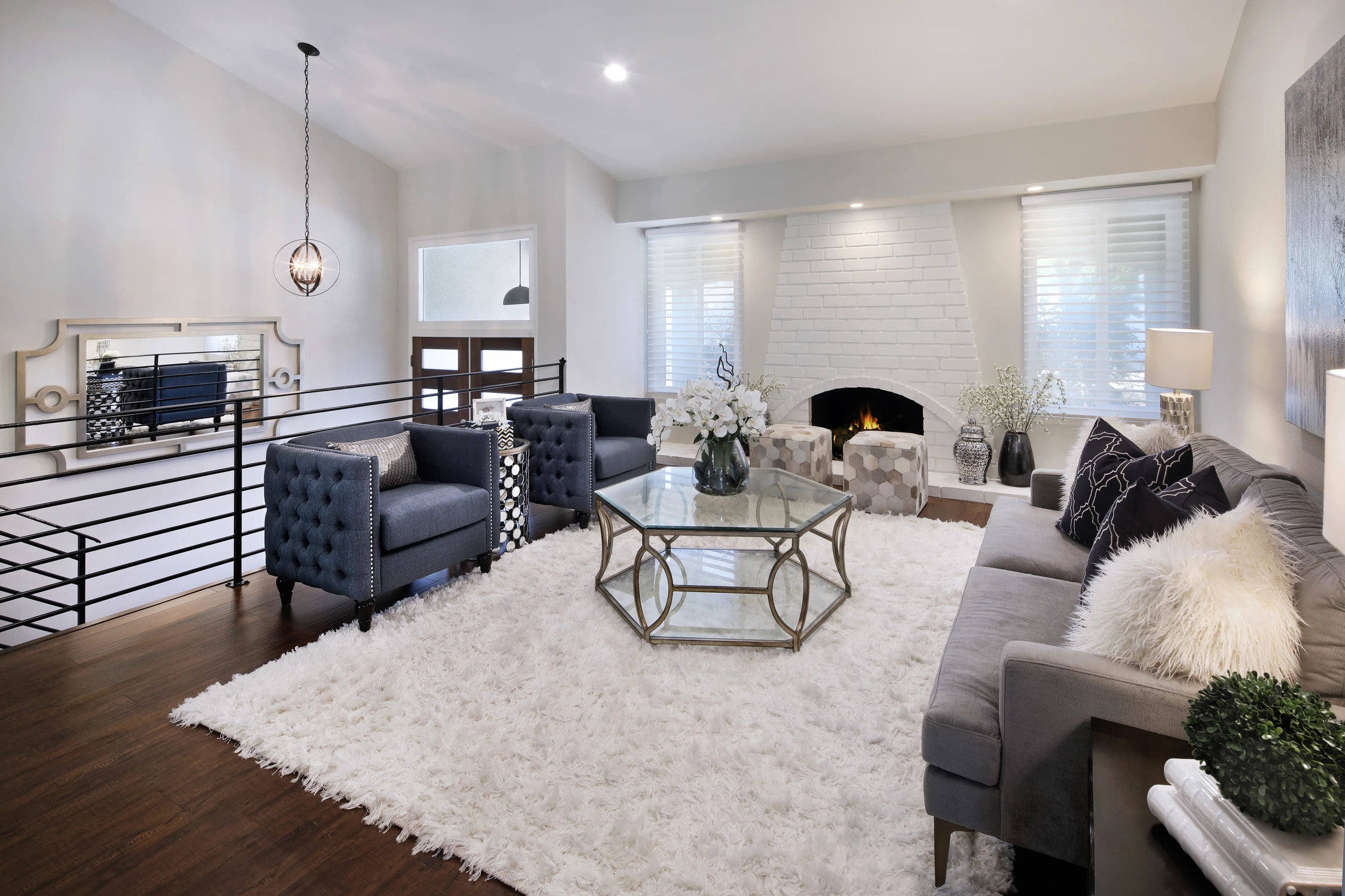 Lounge with navy chairs, pale sofa, and white fireplace