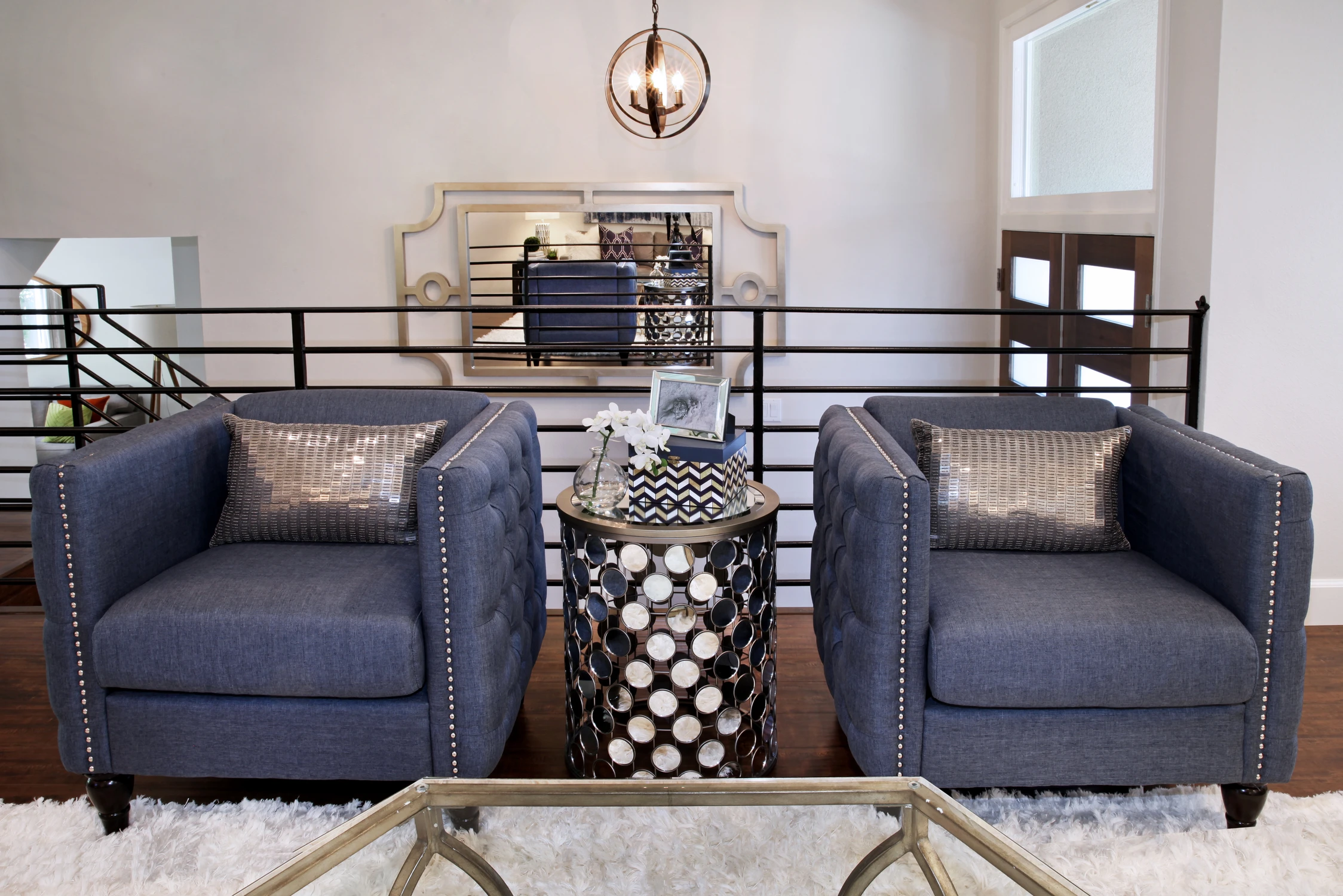 Pair of navy chairs beside a patterned black side table