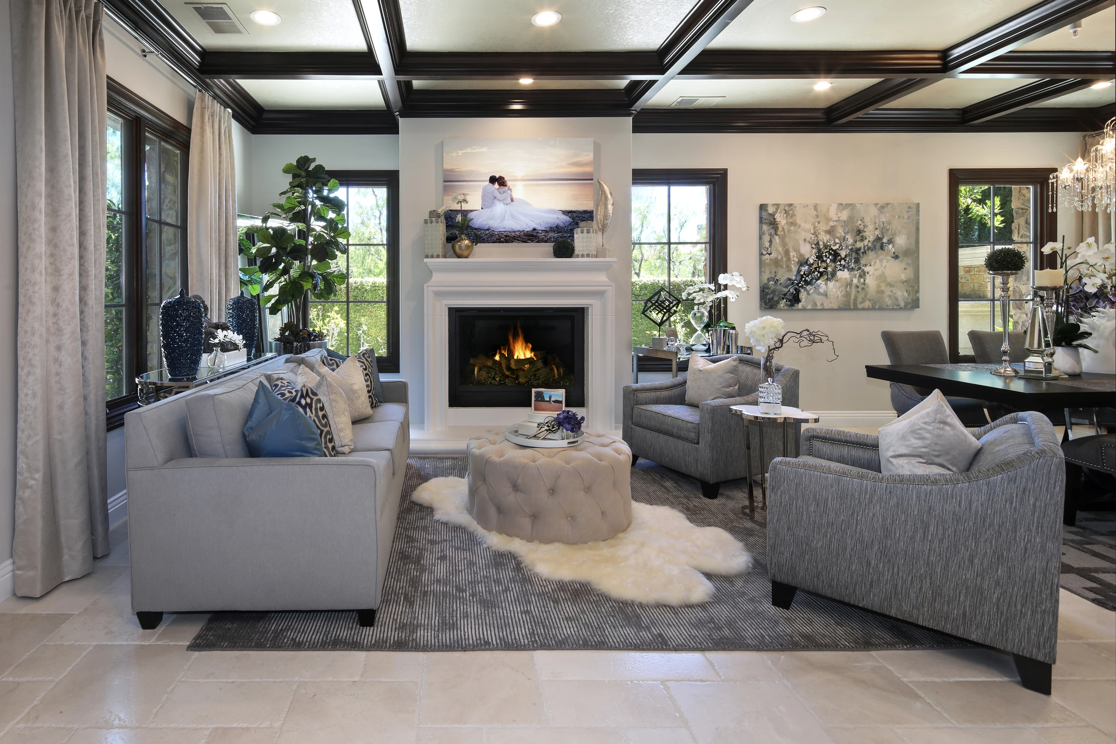 Formal living room with coffered ceiling, gray sofas, and fireplace