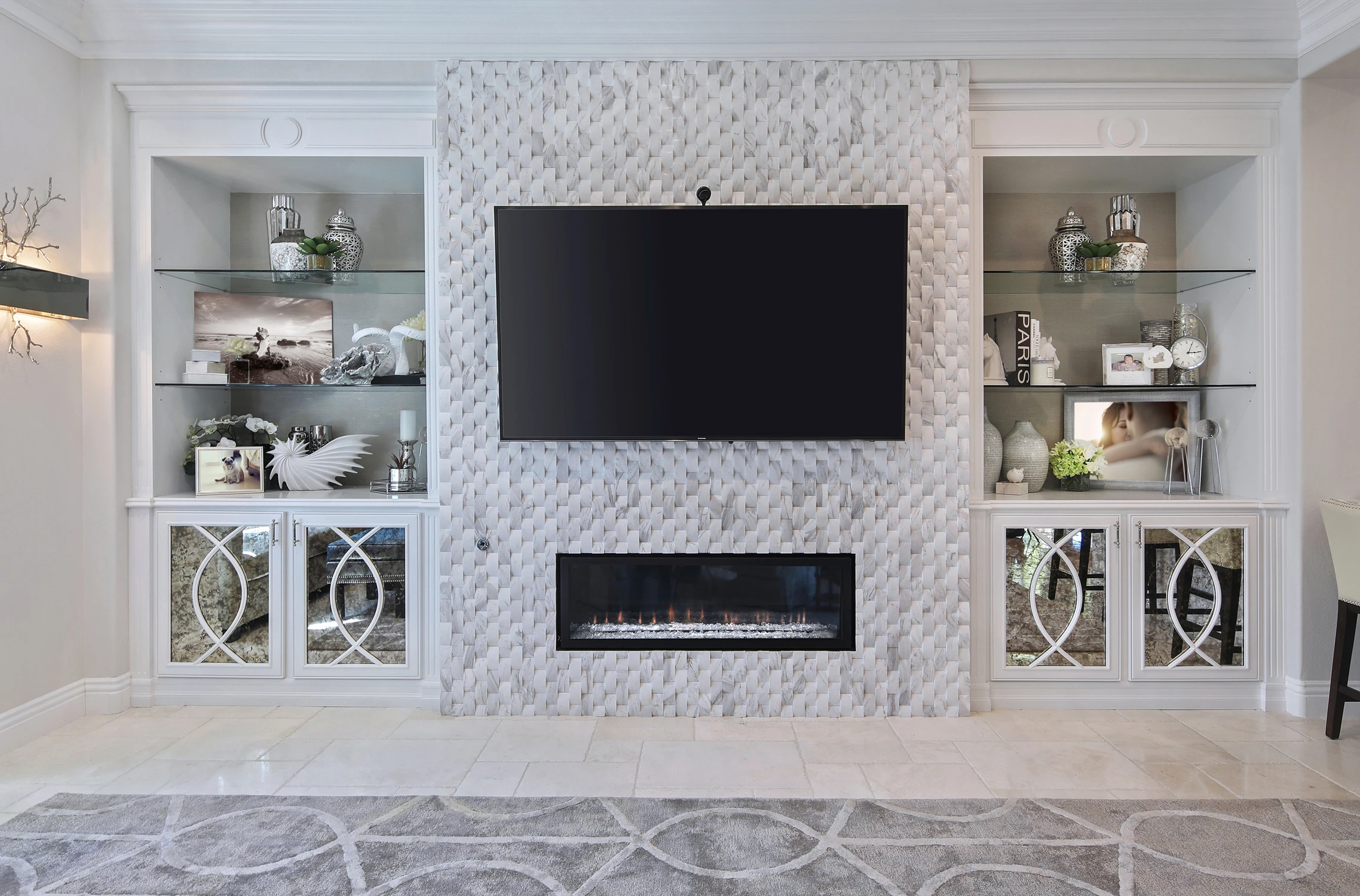 White media wall with television, linear fireplace, and glass cabinets