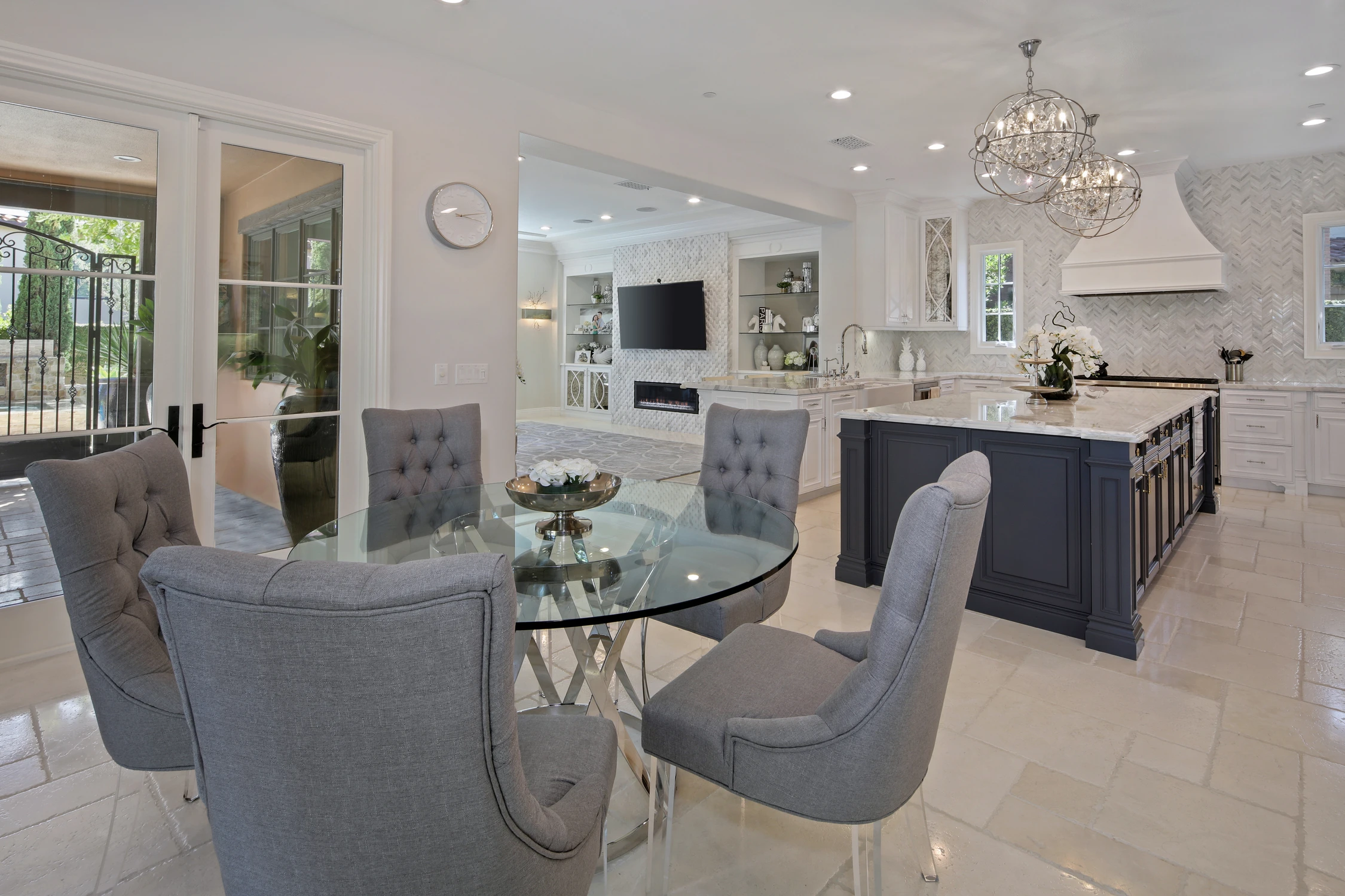 Kitchen dining nook with gray chairs and navy island beyond