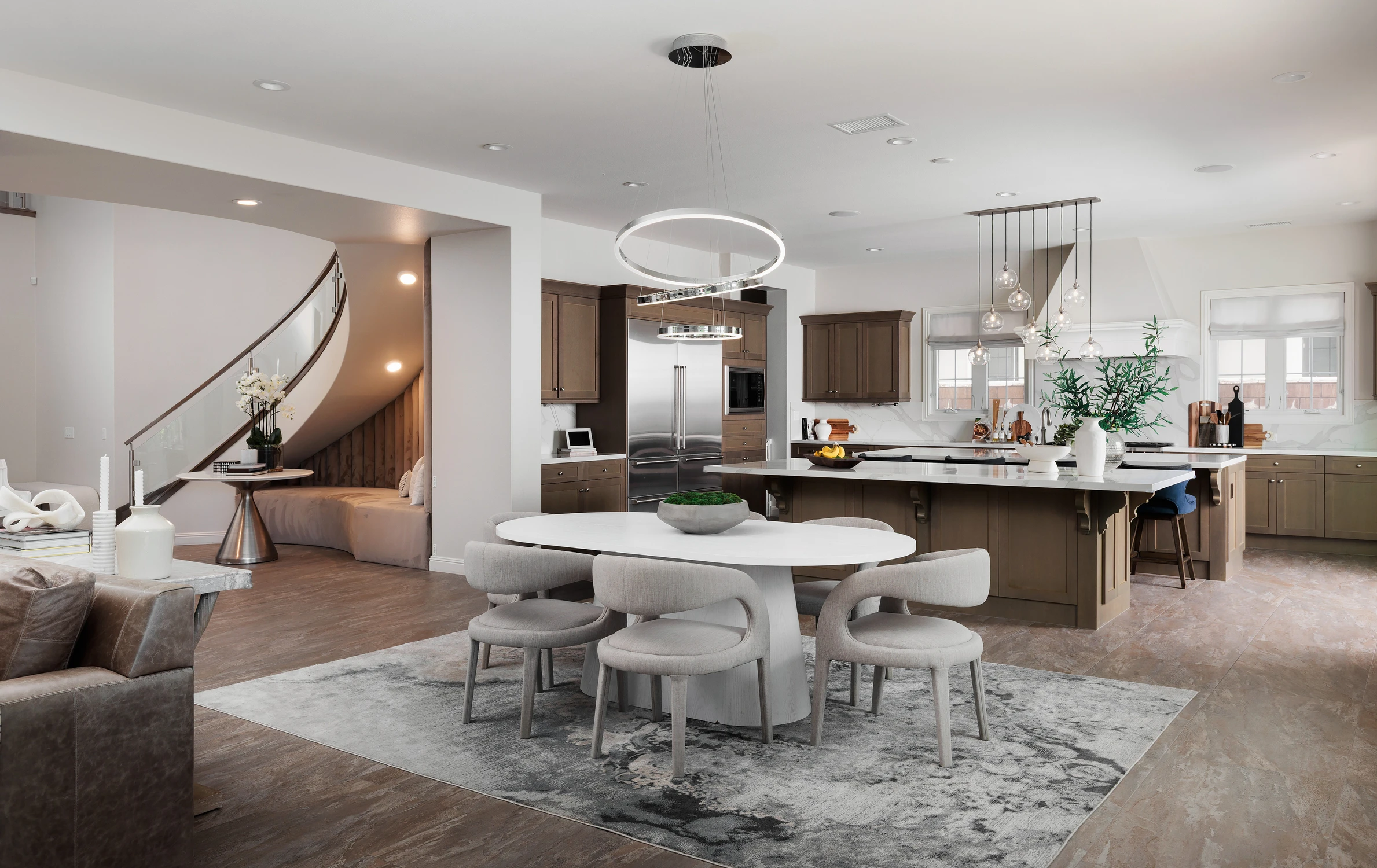 Dining area facing the kitchen beneath circular pendant lights