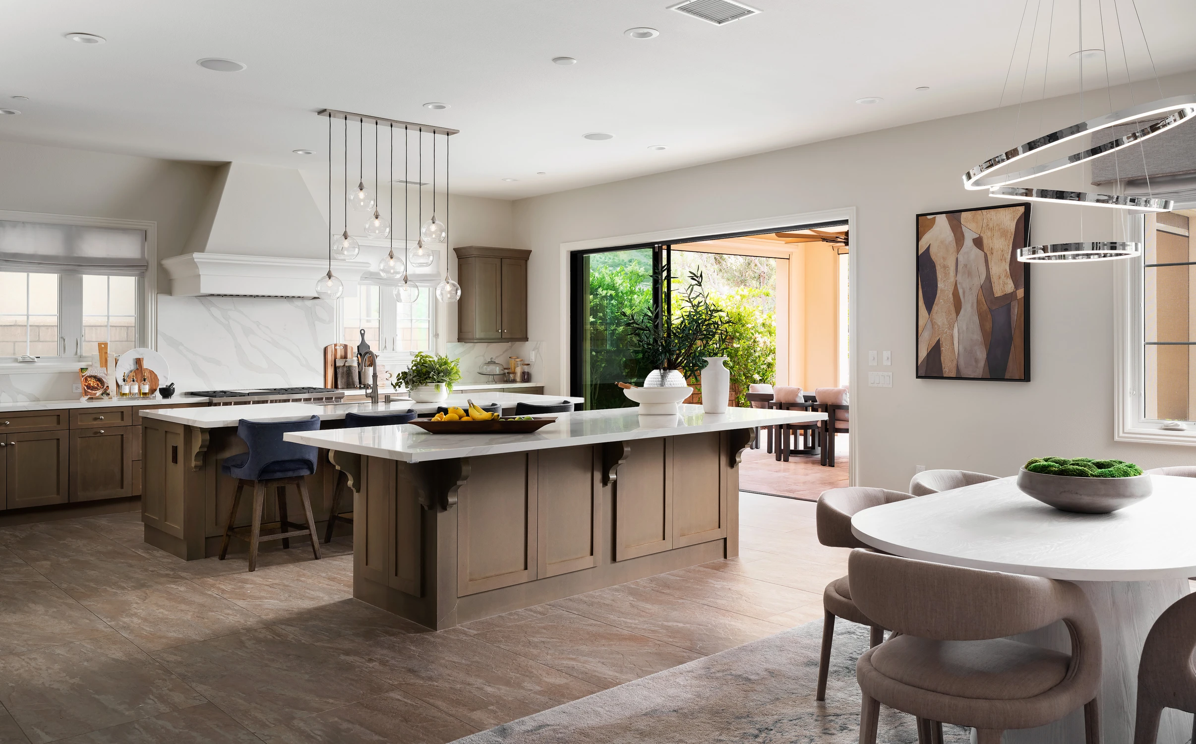 Kitchen and dining area with layered islands and pendant lights