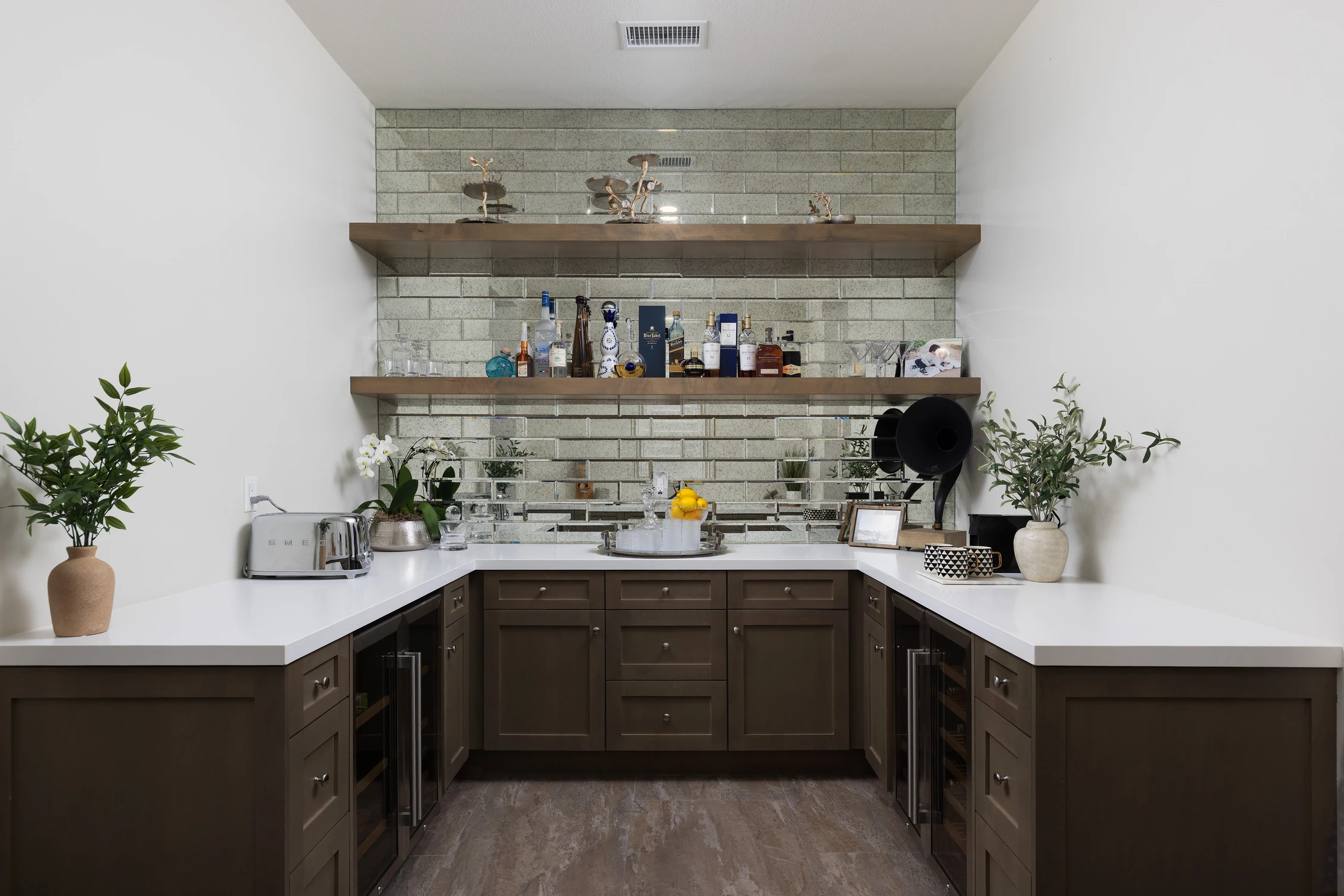Bar area with mirrored tile backsplash and open shelving