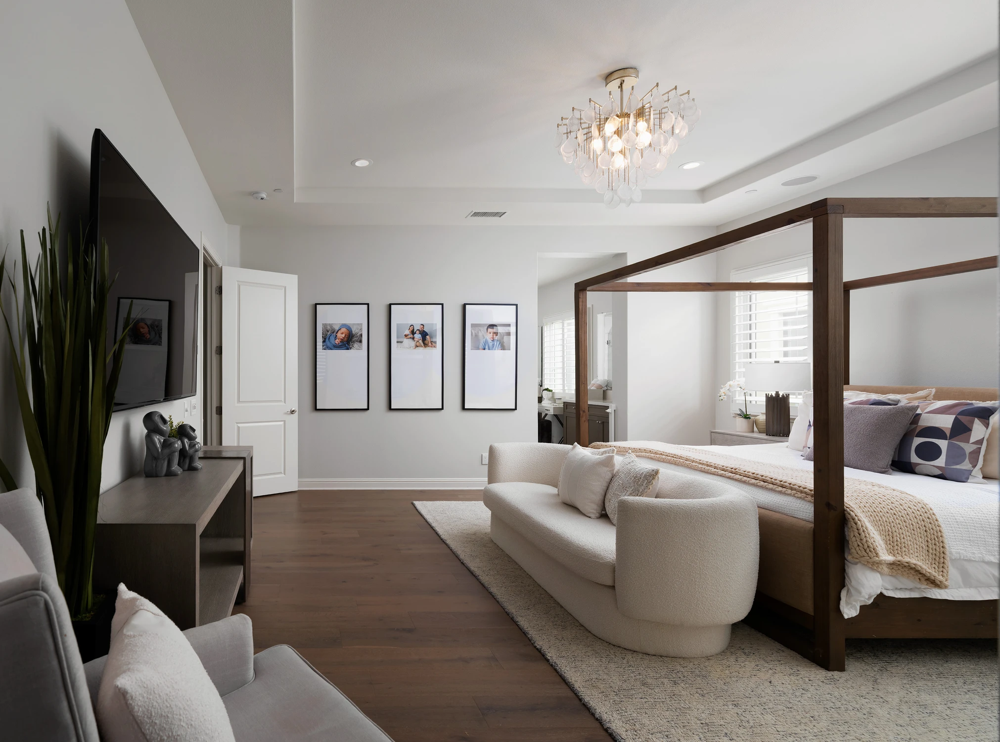 Bedroom with four-poster bed, framed art, and television
