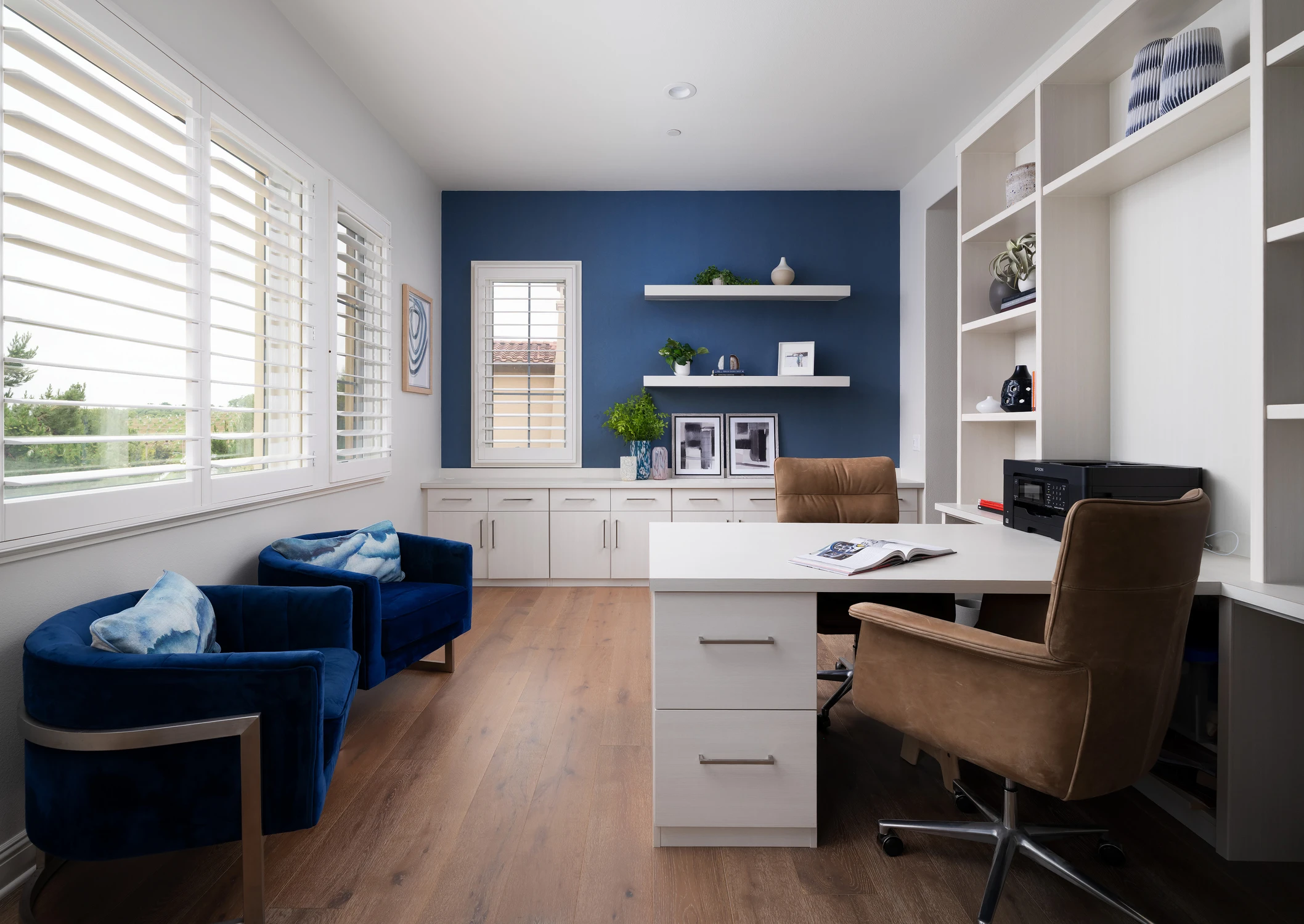 Home office with blue accent wall and built-in shelving