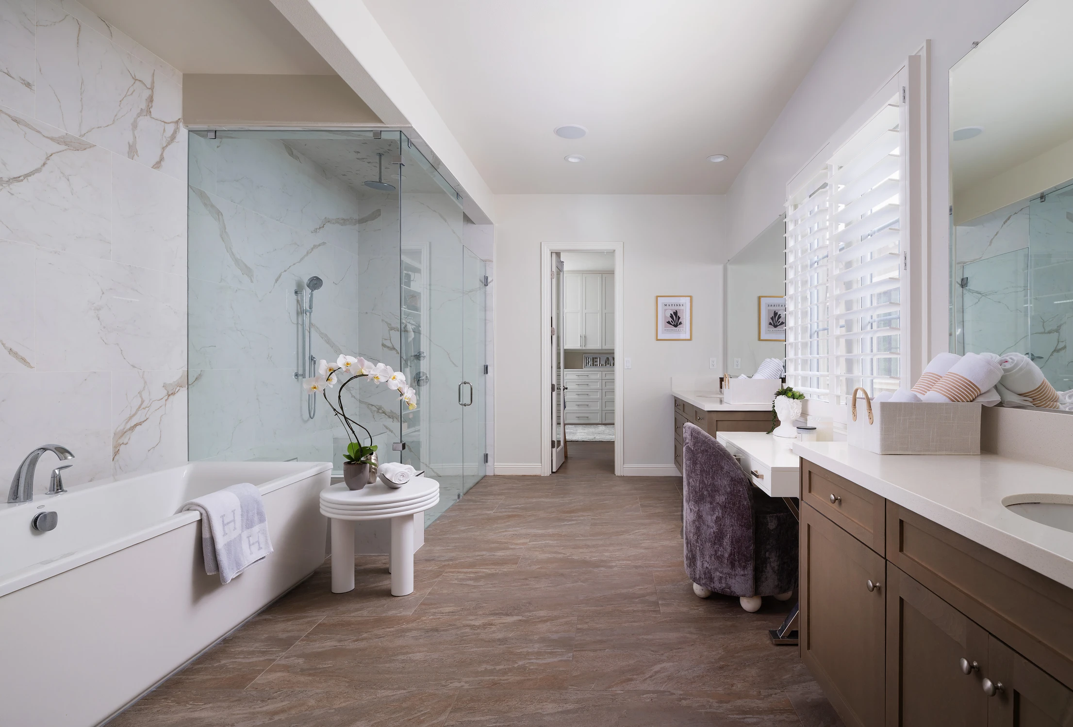 Bathroom with freestanding tub, glass shower, and long vanity