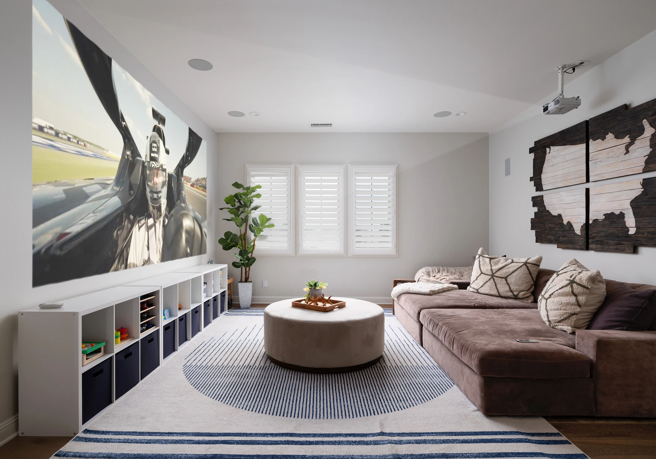 Family room with projector, sectional sofa, and striped rug