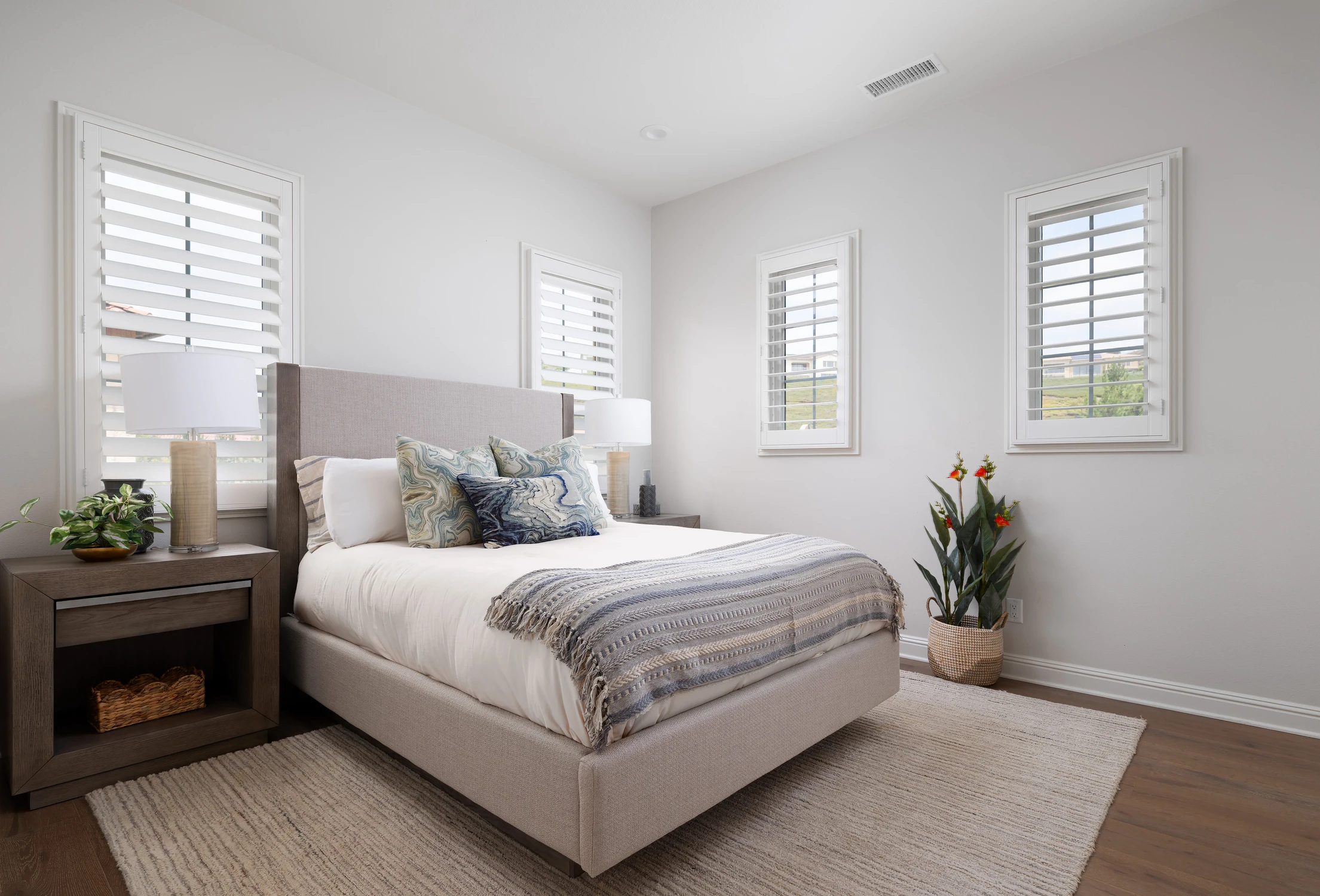 Bedroom with blue patterned bedding and shuttered windows
