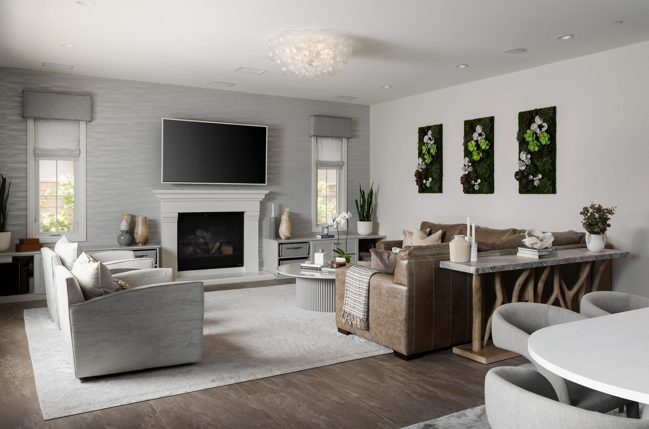 Living room with fireplace, sectional seating, and botanical artwork