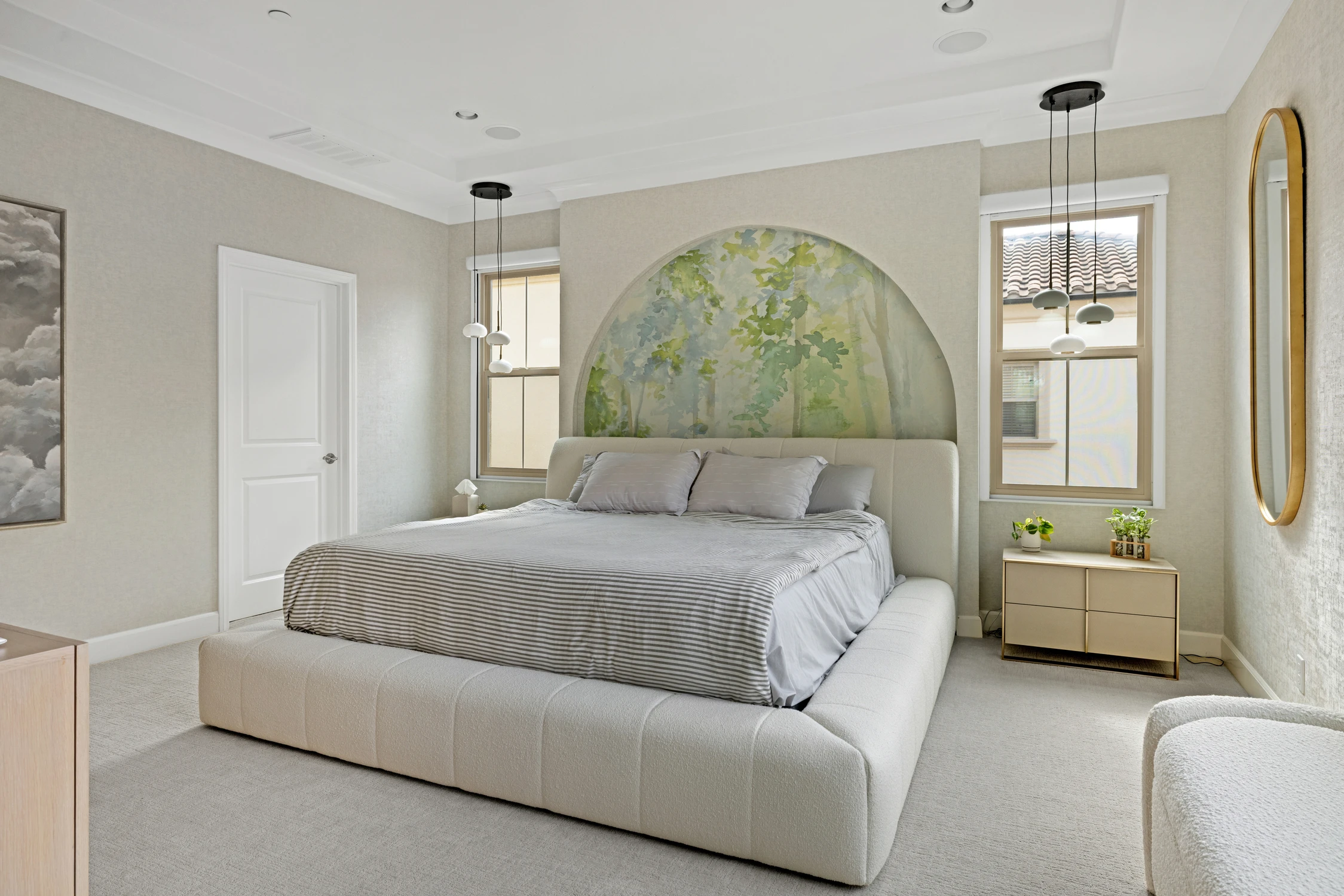 Bedroom with arched botanical mural, upholstered bed, and hanging pendants