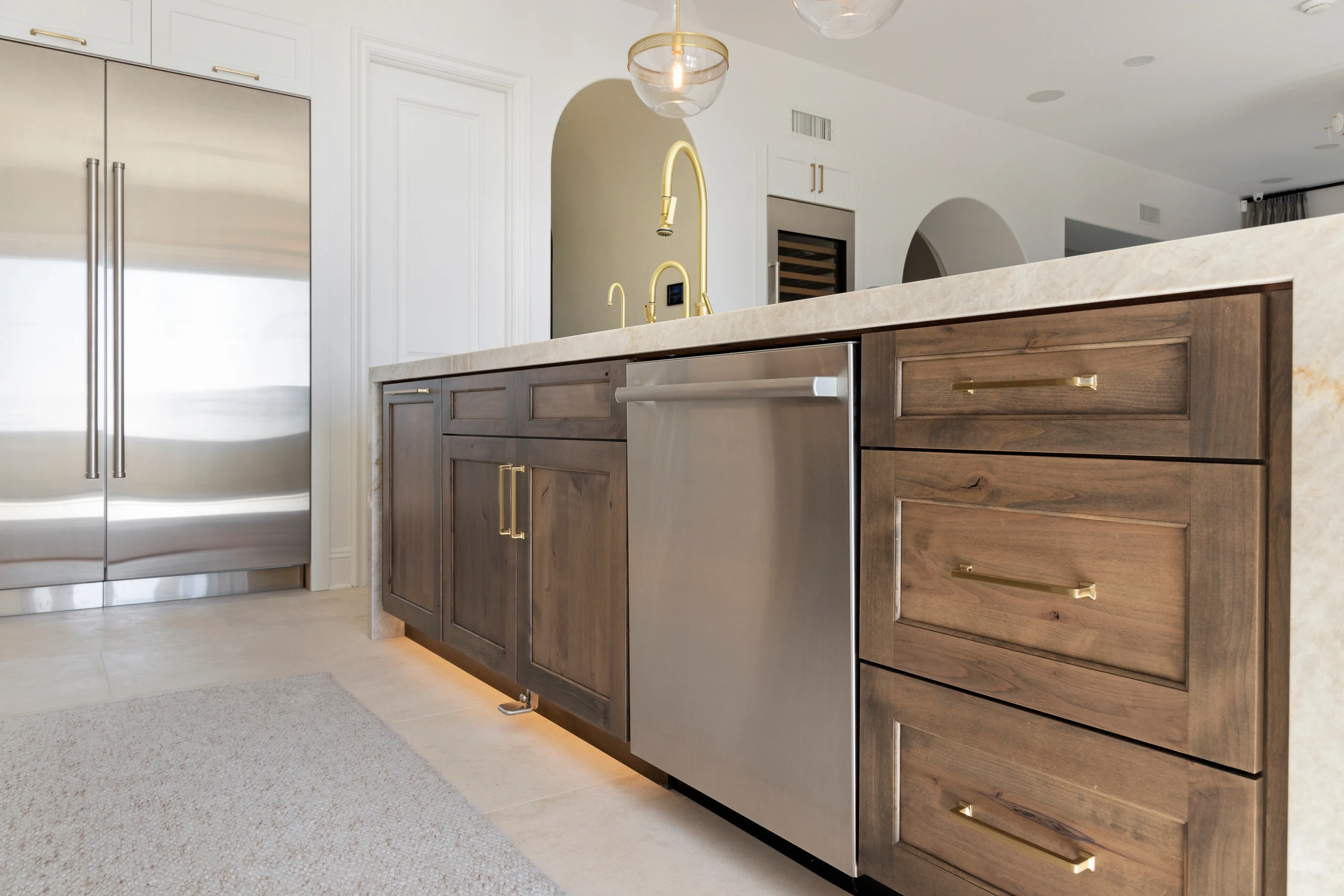 Dark wood kitchen island cabinetry beneath white counter overhang