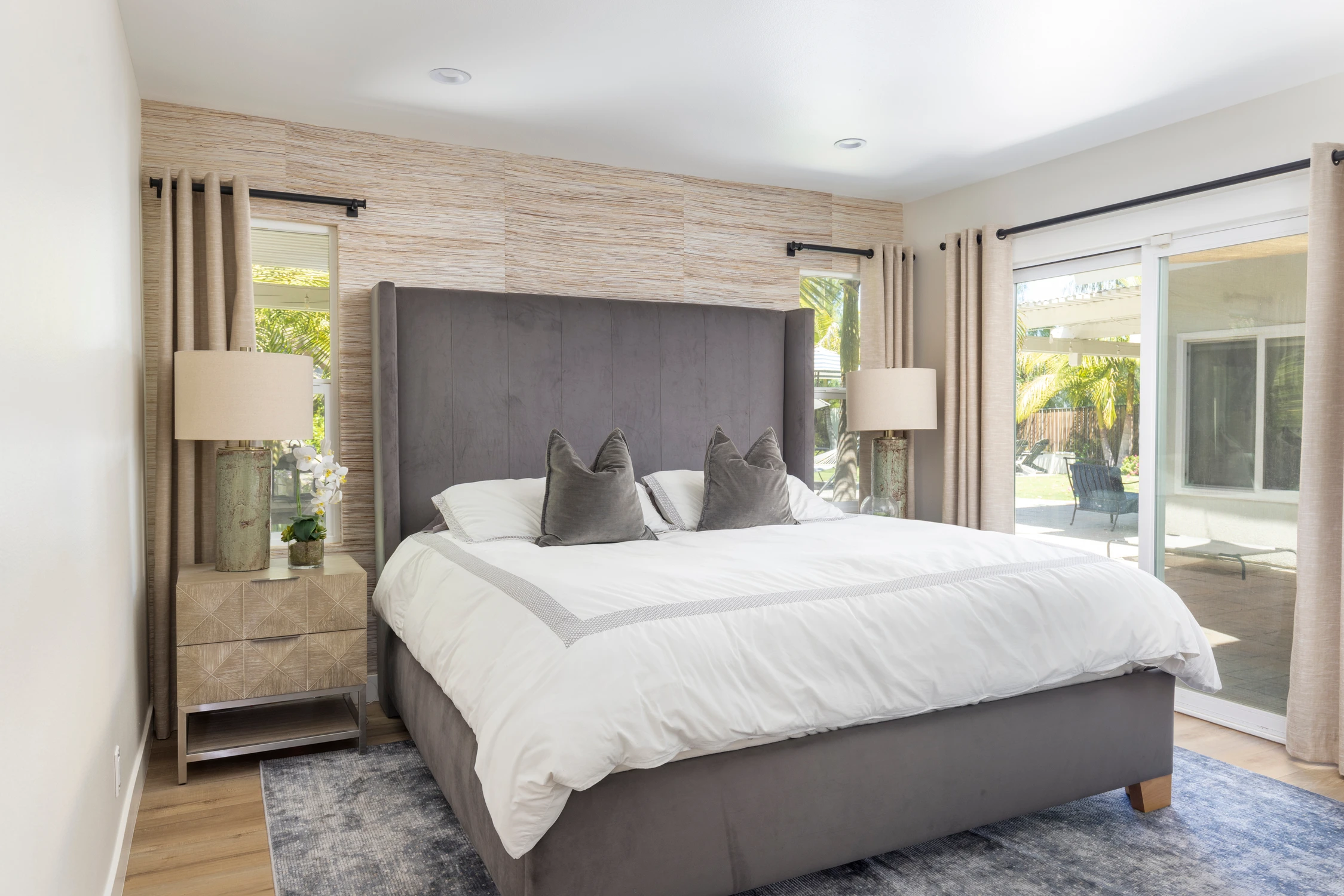 Bedroom with dark gray upholstered bed and wide glass doors