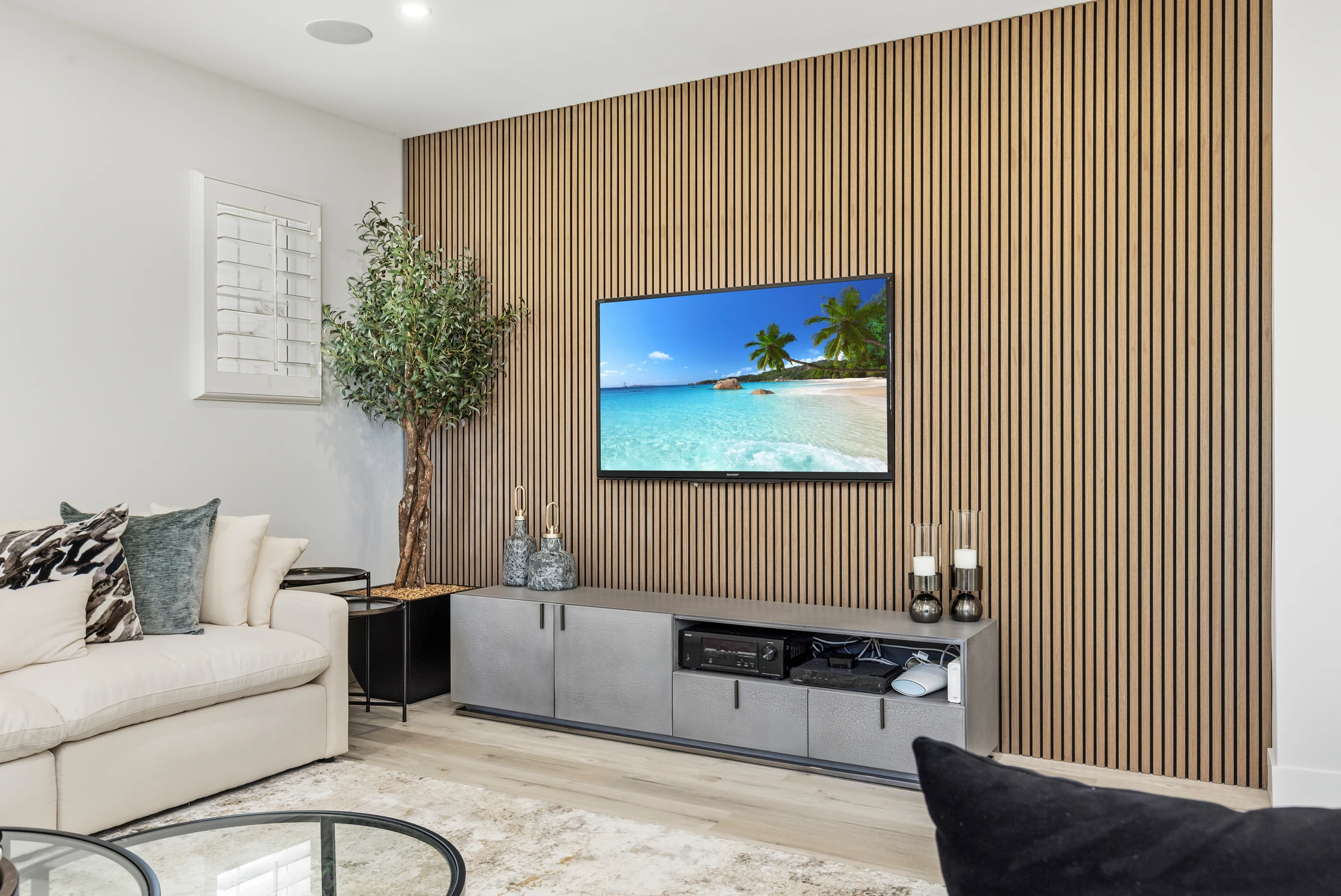 Slatted wood media wall with television and low gray cabinet