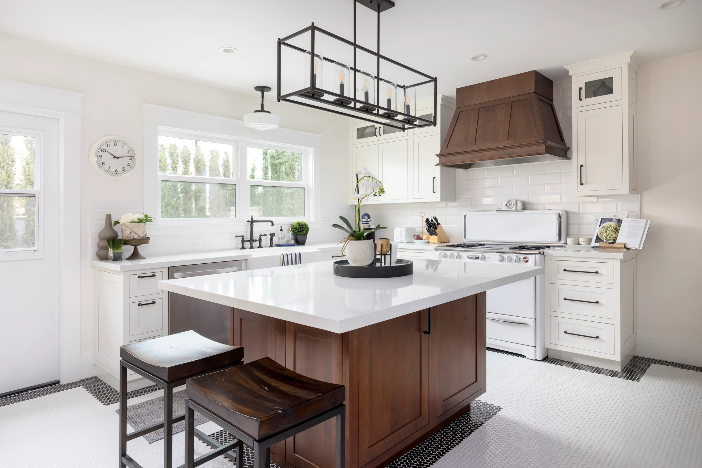 Bright white kitchen with walnut island and black geometric pendant