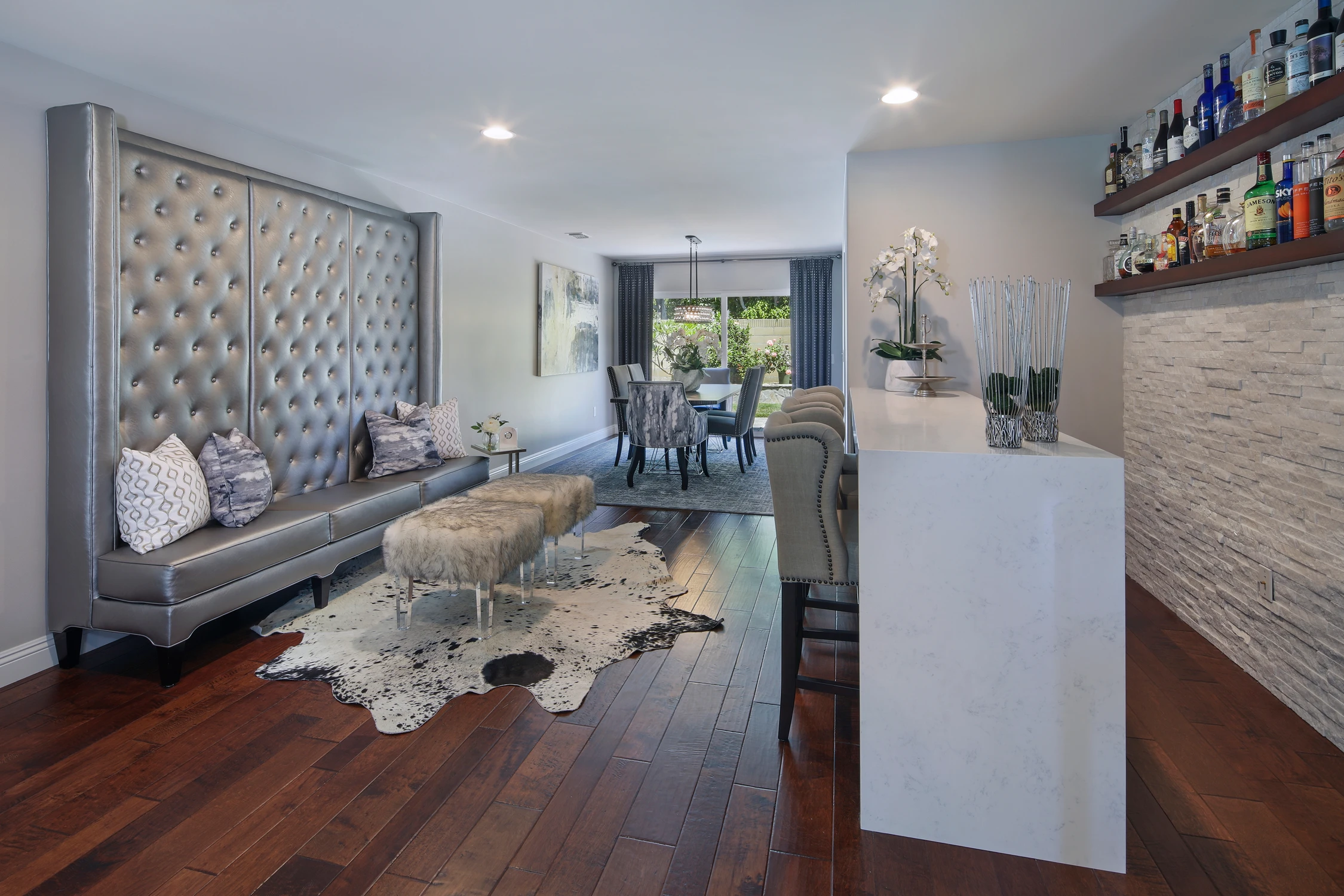 Long tufted bench seating facing a white bar with textured wall