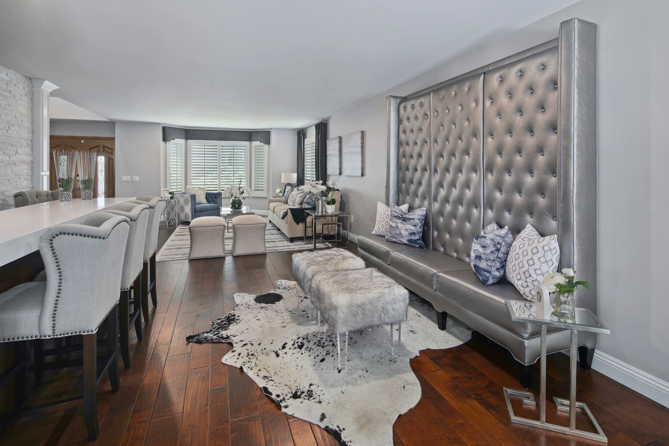 Open bar area with tall tufted bench and dark wood floor