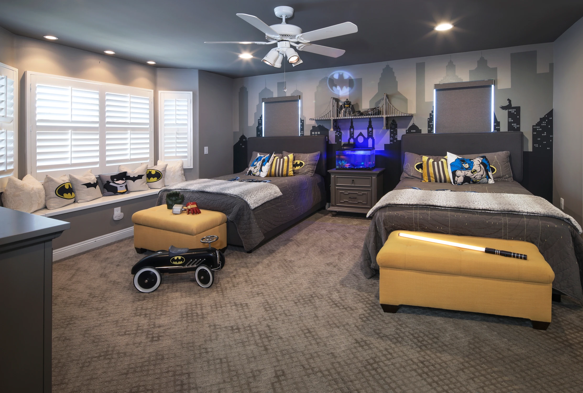 Children's bedroom with dark twin beds, themed wall mural, and blue lighting