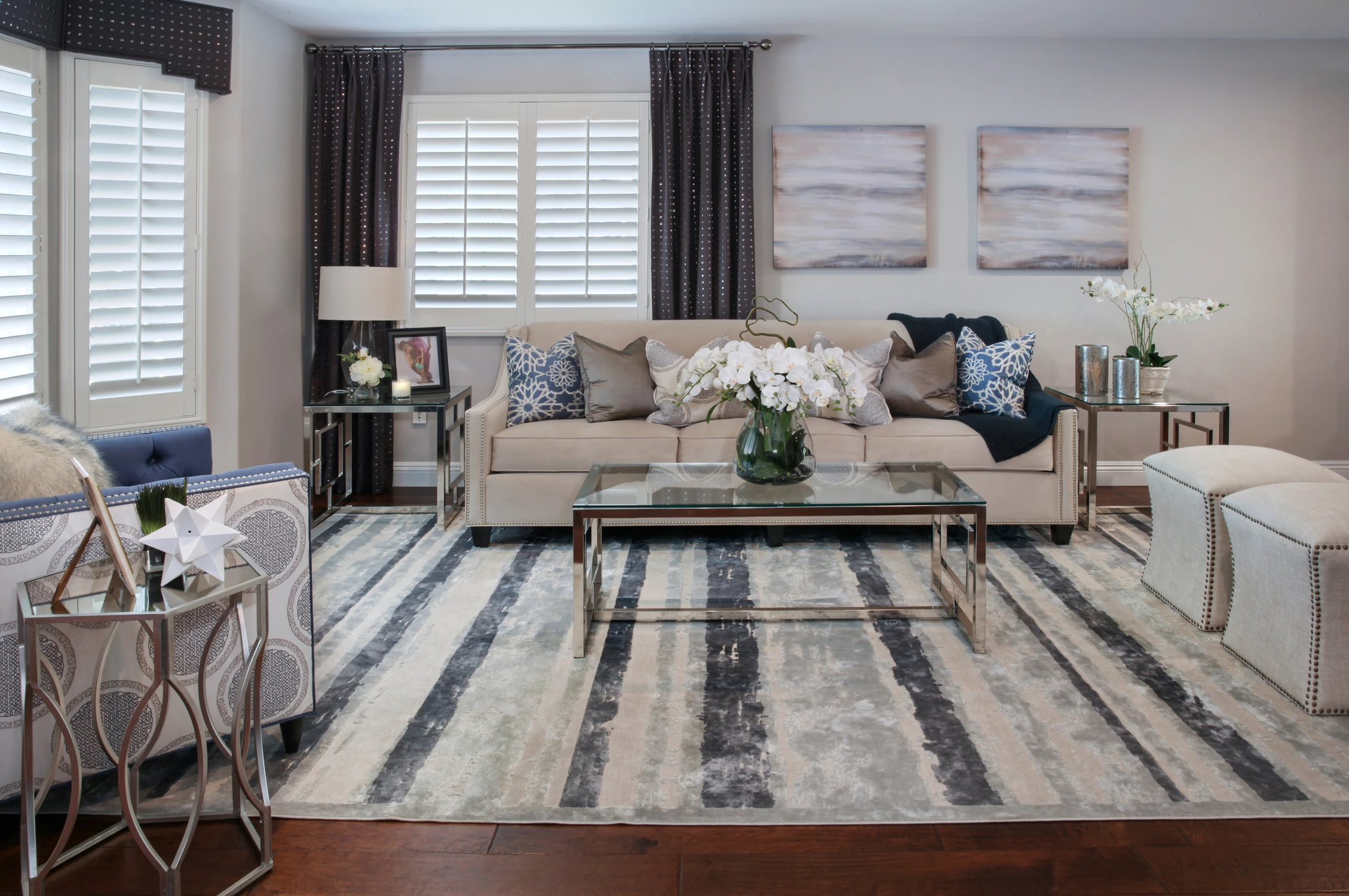 Living room with pale sofas, patterned rug, and dark wood floor