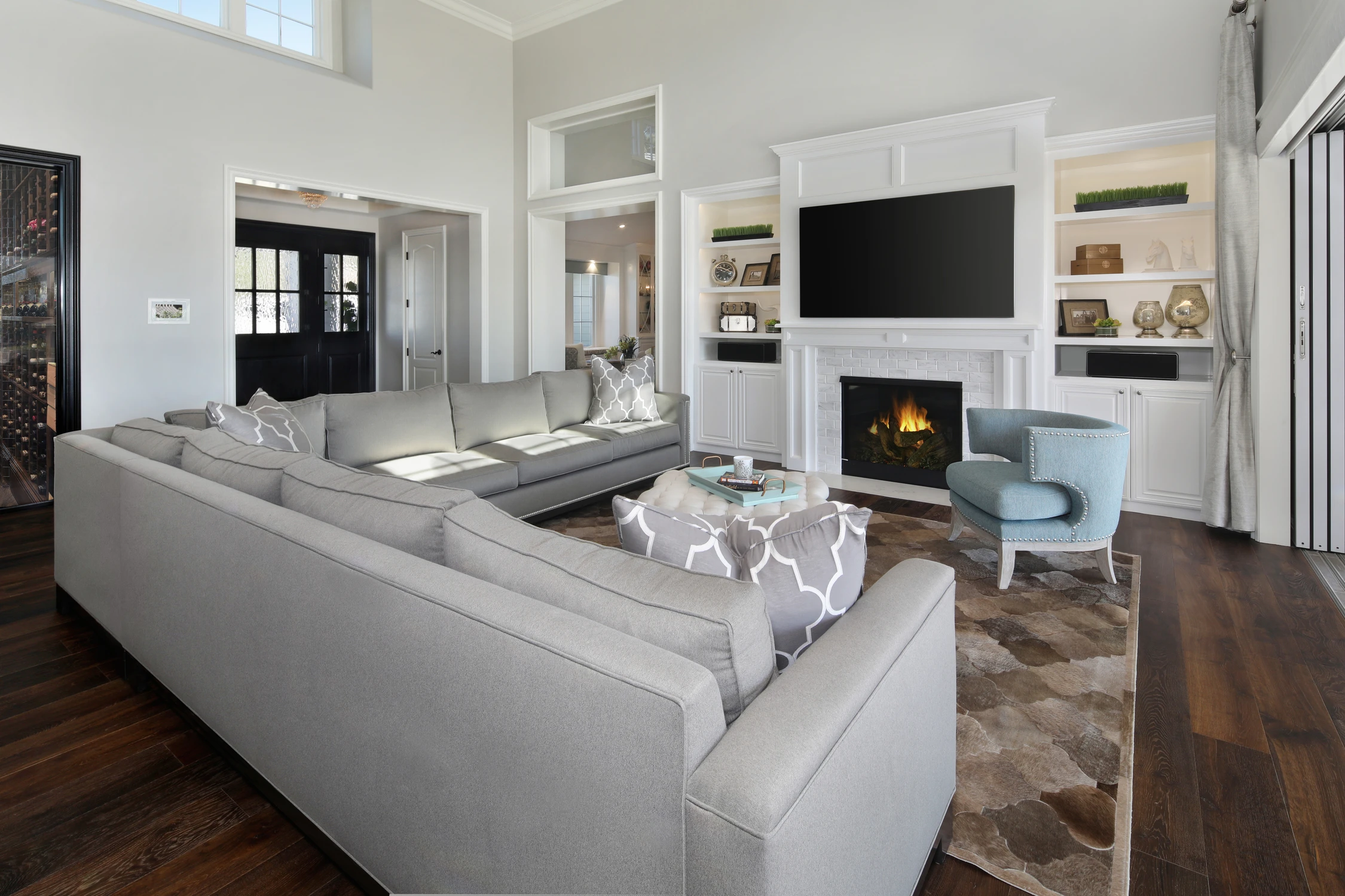 Living room with gray sofa, patterned rug, and wide framed doorway