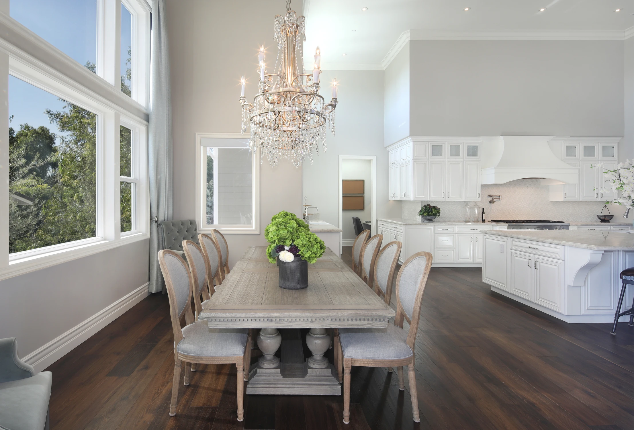 Dining table with oval back chairs beneath a crystal chandelier